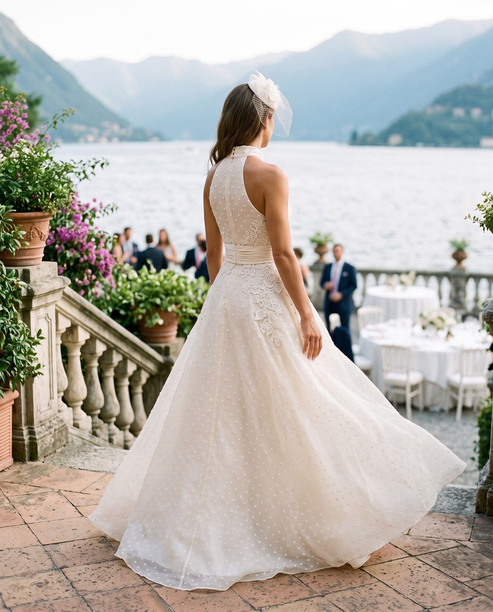 Progetto della Maison: lo stesso abito visto di spalle, con il fascinator coordinato, sulla terrazza di una villa sul lago